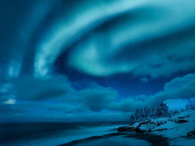 Aurora Borealis in Norwegen Grüne Nordlichter über Bergen und Ozean Nächtliche Winterlandschaft mit Aurora Naturphänomen Hintergrund in Norwegen