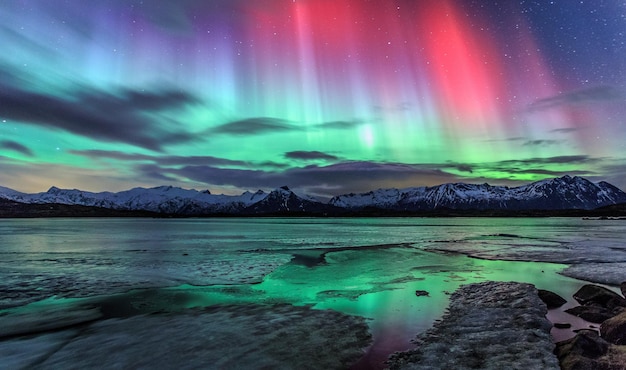 Aurora polar sobre el lago contra el cielo por la noche