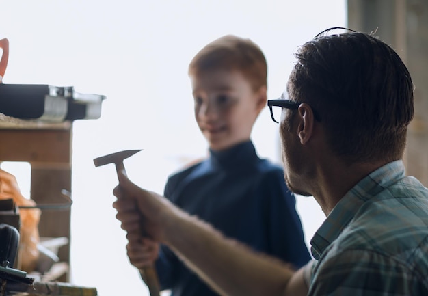 Aus der Nähe stehen der Vater und sein kleiner Sohn in der heimischen Garage das Konzept des Lernens in der Familie