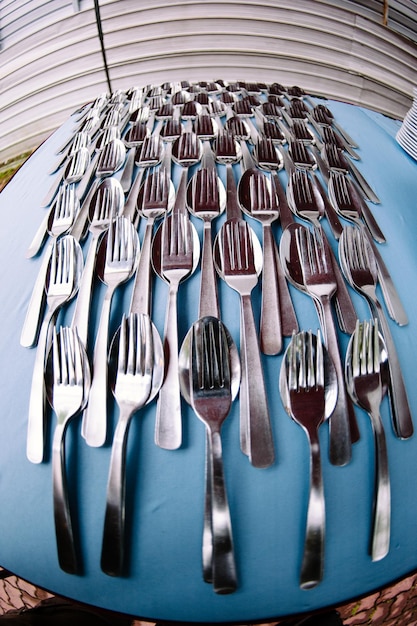 Foto aus der sicht eines fisches von löffeln und gabeln, die auf einem tisch in einem restaurant angeordnet sind