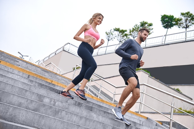 Aus für einen Lauf in voller Länge eines jungen Paares in Sportkleidung, das durch die