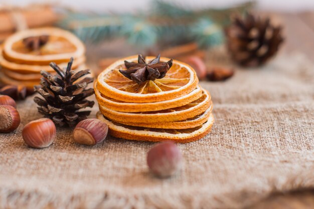 aus getrockneten Orangen, Nüssen, Anis-Nelken und Zapfen auf rustikalem Sackleinen Winter aromatische Komposition