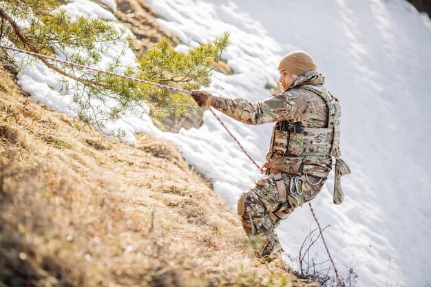 Ausbilder, der einem anderen Soldaten hilft, den Hügel hinaufzuklettern Menschen und militärisches Konzept