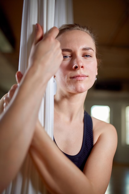 Ausbilderin in Aerial Yoga Portrait Nahaufnahme Hipster-Mädchen mit einem ausdrucksstarken Blick Yoga-Trainerin posiert für die Kamera Konzept Yoga flexibler Körper gesunder Lebensstil Fitness