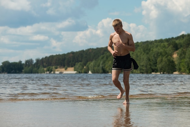 Ausbildung eines jungen Mannes am Strand. Ein junger Mann beim morgendlichen Joggen