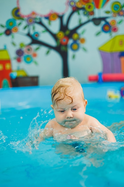 Ausbildung eines Neugeborenen in einem Schwimmbad Ein Schwimmbad für Babys Kindesentwicklung Ein kleines Kind lernt im Schwimmbad schwimmen