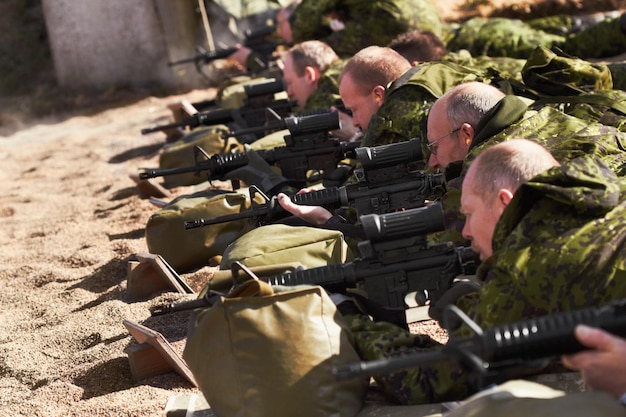 Ausbildung zum Scharfschützen. Eine Reihe von Soldaten, die liegen und mit ihren Waffen zielen.