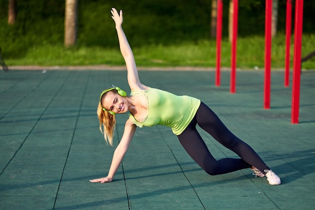 Ausdehnen der Sitz- oder Tänzerfrau, die Übung im Trainingssportplatz tut