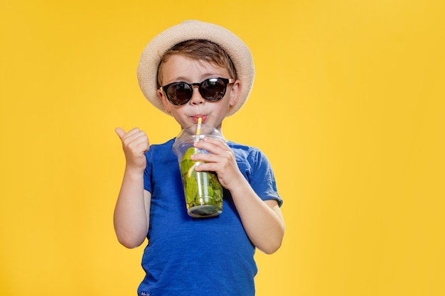 Ausdrucksstarker Junge posiert mit einem Glas Getränk
