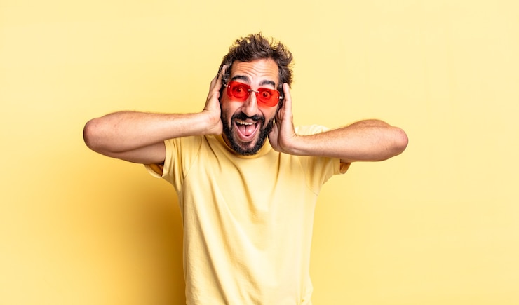 Foto ausdrucksstarker verrückter bärtiger mann mit sonnenbrille mit kopierraum gegen gelbe wand