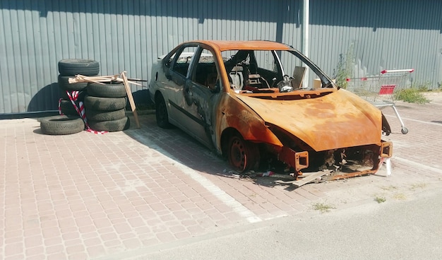 Ausgebranntes Auto, das auf einem städtischen Parkplatz steht