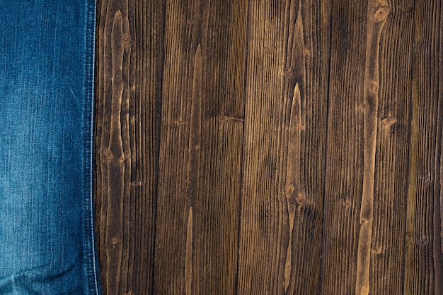 Ausgefranste Jeans oder Blue Jeans-Denim-Kollektion auf rauem dunklem Holz