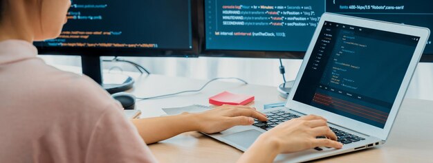 Ausgeschnittenes Bild einer Webentwicklerin, die auf einem Laptop programmiert, während der Computer Programm- und Softwarecode im modernen Büro anzeigt Nahaufnahme einer Geschäftsfrau mit der Hand, die sich auf Analysedaten konzentriert Aufkeimende Entwicklung
