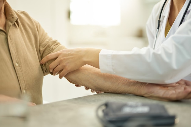 Ausgeschnittenes Foto des Arztes, der den Patienten auf die Blutdruckuntersuchung vorbereitet