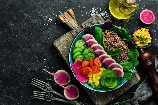 Ausgewogenes Essen Quinoa Wassermelone Rettich Gurke Tomaten und Spinat Buddha Schüssel leckeres Essen Konzept auf Stein Hintergrund