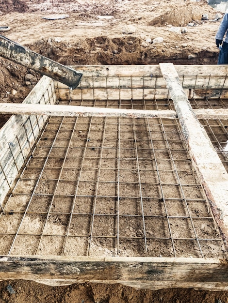 Ausgießen des Fundaments mit Beton auf der Baustelle Monolithische Stahlbetonarbeiten während der Errichtung des Gebäudes