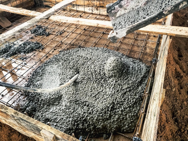 Ausgießen des Fundaments mit Beton auf der Baustelle Monolithische Stahlbetonarbeiten während der Errichtung des Gebäudes