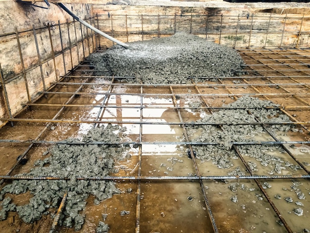Ausgießen des Fundaments mit Beton auf der Baustelle Monolithische Stahlbetonarbeiten während der Errichtung des Gebäudes