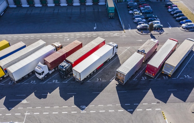 Foto ausladung von lastwagen im logistikzentrum, luftansicht