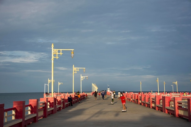 Ausländische Reisende aus Thailand reisen, besuchen sich, entspannen sich und trainieren beim Sport-Skateboard auf der roten Brücke von Saphan saranwithi am Strand von Prachuap Bay am 6. September 2021 in Prachuap Khiri Khan Thailand