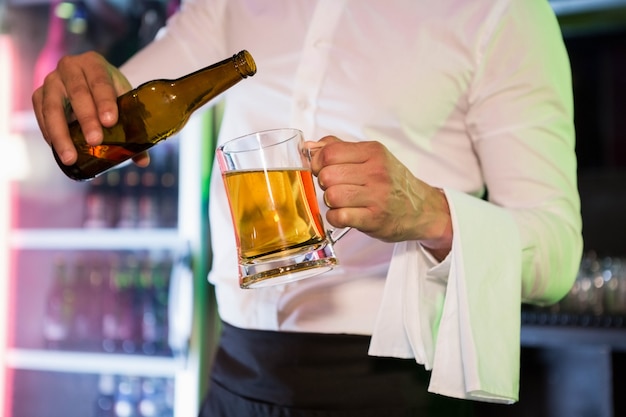 Auslaufendes Bier des Barmixers in einem halben Liter in der Bar