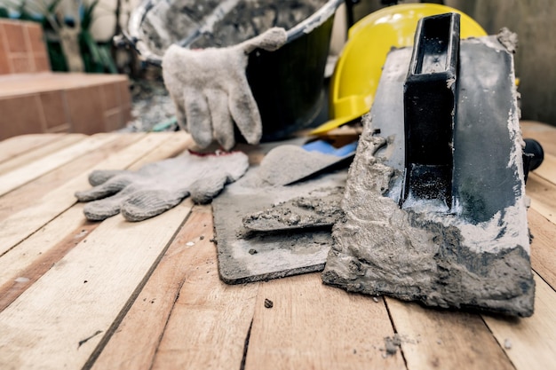 Ausrüstung und Werkzeuge für den Hochbau auf Holzhintergrund. Arbeitstag und Arbeiterkonzept.