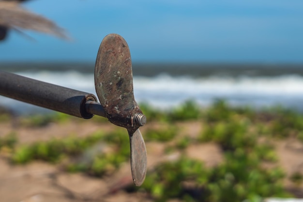 Außenbordmotor asia Bootsmotor alter rostiger Stahlpropeller zwei Blätter an Metallstange hängt Naturhintergrund Gerät mit rotierender Nabe und strahlenden Blättern, die auf Tonhöhe eingestellt sind, um eine spiralförmige Spirale zu bilden, die gedreht wird