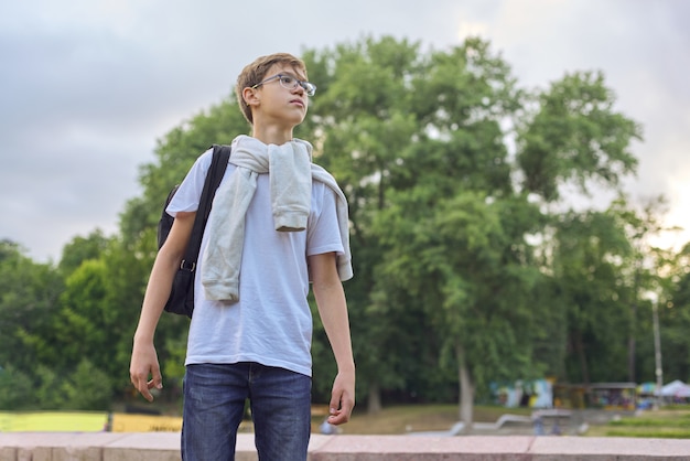 Außenporträt des Teenagerjungen mit Brillenrucksack