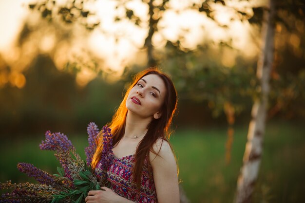 Außenporträt einer schönen jungen Altersbrünette. attraktives sexy Mädchen in einem Feld mit Blumen