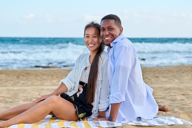 Außenporträt eines glücklichen jungen Paares am Sandstrand