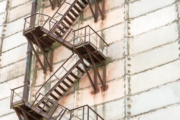 Außentreppe aus Metall an der Fassade eines verlassenen Fabrik- oder Unternehmensgebäudes