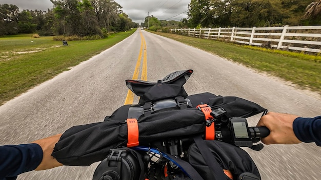 Foto aussichtspunkt fahrradlenker mit fahrradverpackungsgeräten auf ländlicher straße