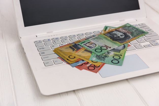 Australische Dollar-Banknoten auf weißer Laptop-Tastatur