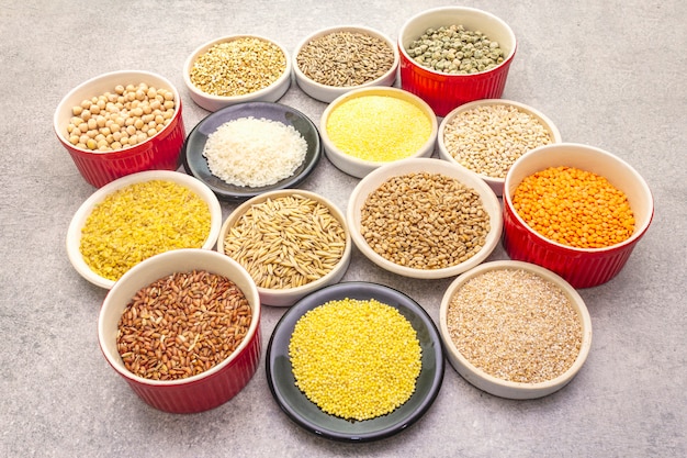 Auswahl an bio-getreide, hülsenfrüchten und vollkornprodukten in schalen