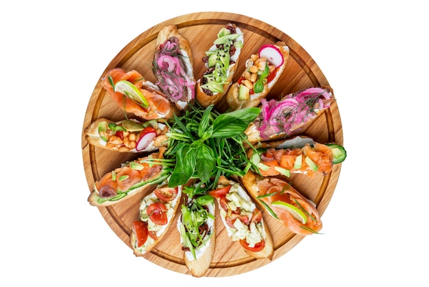 Auswahl an Bruschettas mit verschiedenen Belägen, serviert auf einem runden Holzteller Appetitlich beliebte Buffet-Snacks Draufsicht Nahaufnahme Isoliert auf weißem Hintergrund