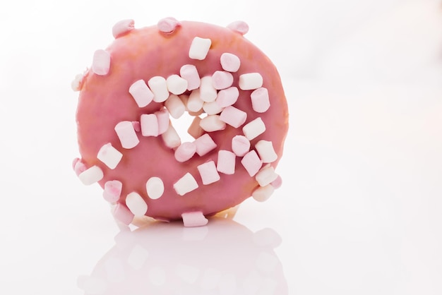 Auswahl an Donuts in verschiedenen Geschmacksrichtungen, rosa glasierter Marshmallow-Donut, hell und bunt bestreut