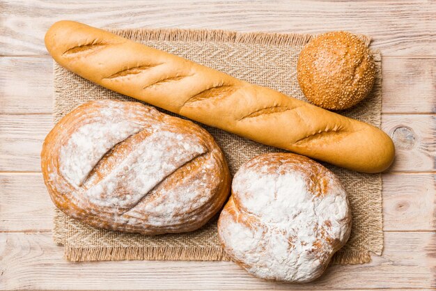 Auswahl an frisch gebackenem Brot mit Serviette auf rustikaler Tischplatte Ansicht Gesundes ungesäuertes Brot Französisches Brot
