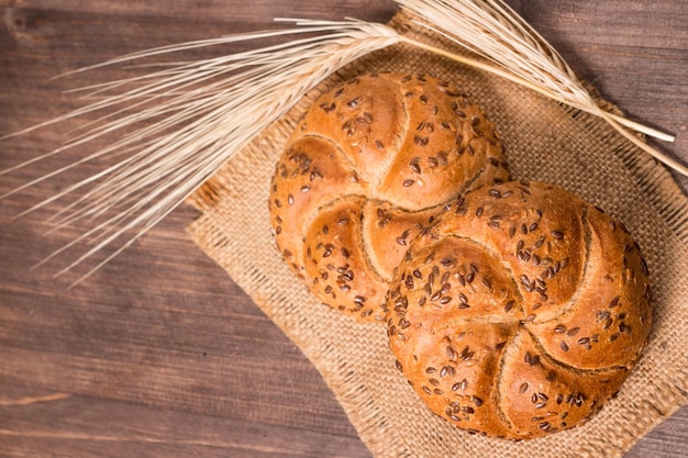 Auswahl an gebackenem Brot mit Samen auf einem Holztischhintergrund. Bäckerei. Ernährungssicherheitskonzept.