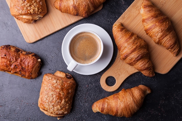 Auswahl an Gebäck mit Kaffeetasse auf Holztischhintergrund. Französische Küche.