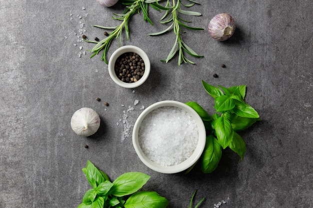 Auswahl an Gewürzen, Kräutern und Gemüse, Zutaten zum Kochen auf dunklem Hintergrund.