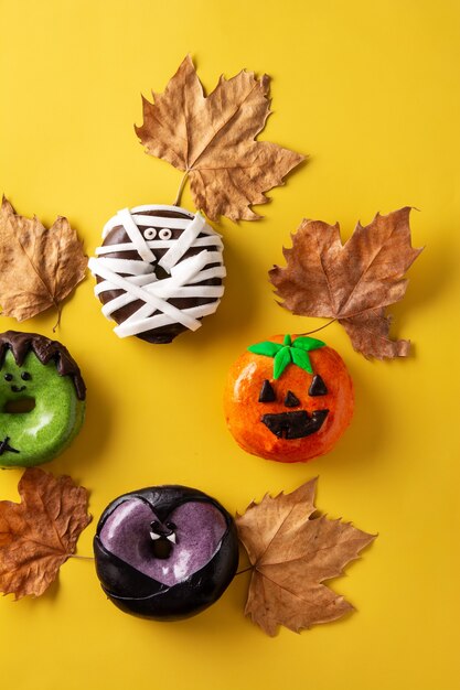 Auswahl an Halloween Donuts auf gelbem Hintergrund