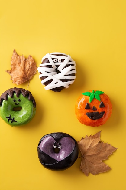 Auswahl an Halloween Donuts auf gelbem Hintergrund