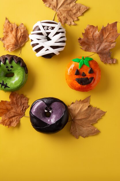 Auswahl an Halloween Donuts auf gelbem Hintergrund