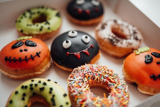 Foto auswahl an halloween-monstern mit lustigen gesichtern donuts in box zu hause innen