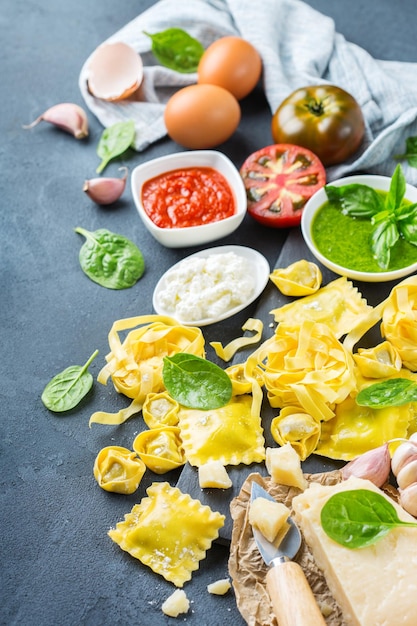 Auswahl an italienischen Speisen und Zutaten Ravioli mit Ricotta und Spinat Pasta Tortellini Pesto Tomatensauce Olivenöl Parmesankäse