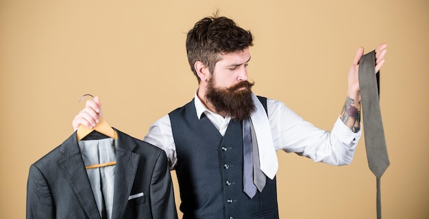 Foto auswahl an kleidung und accessoires hipster, der einkaufswahl im shop trifft geschäftsmann, der das konzept der krawattenauswahl wählt bärtiger mann, der die farbe der krawatte an die anzugsjacke im geschäft anpasst dies ist eine gute wahl