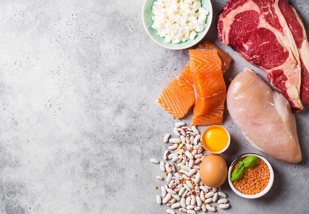 Auswahl an natürlichen Proteinquellen aus der Nahrung: Fleisch, Fisch, Huhn, Milchprodukte, Eier, Bohnen. Ernährung, gesunde Ernährung, Wellness, Bodybuilding-Konzept, Draufsicht, Platz für Text