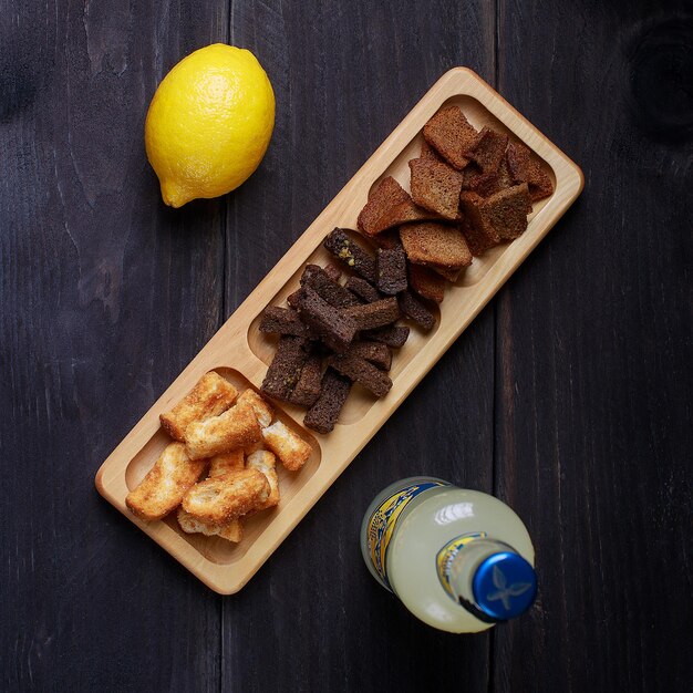 Foto auswahl an ungesunden biersnacks in schüssel auf draufsicht aus dunklem holz