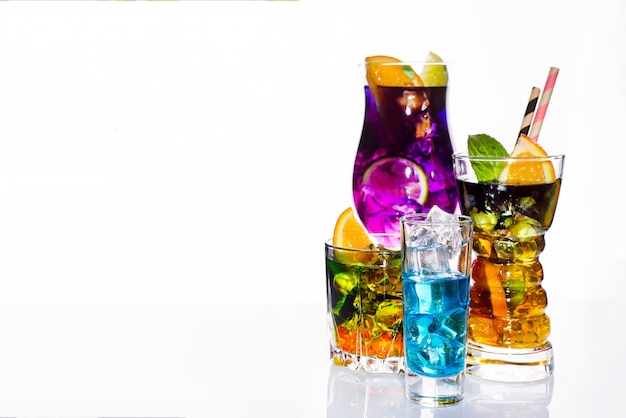 Auswahl von bunten festlichen Getränken, von alkoholischen Getränken und von Cocktails in eleganten Gläsern auf Weiß