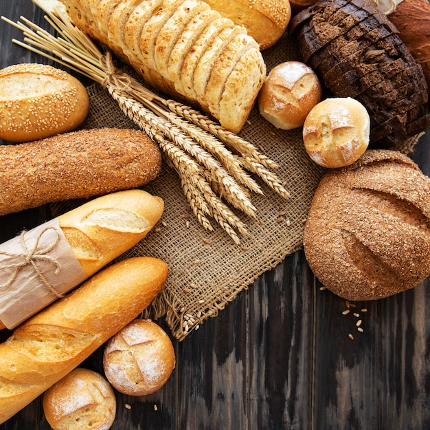 Auswahl von gebackenem Brot auf altem Holzhintergrund